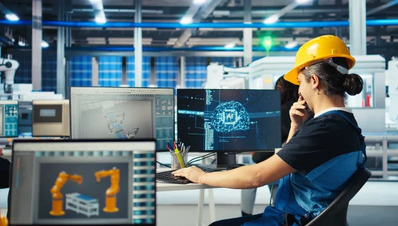 Factory automation engineer programming robotic systems and monitoring smart manufacturing processes